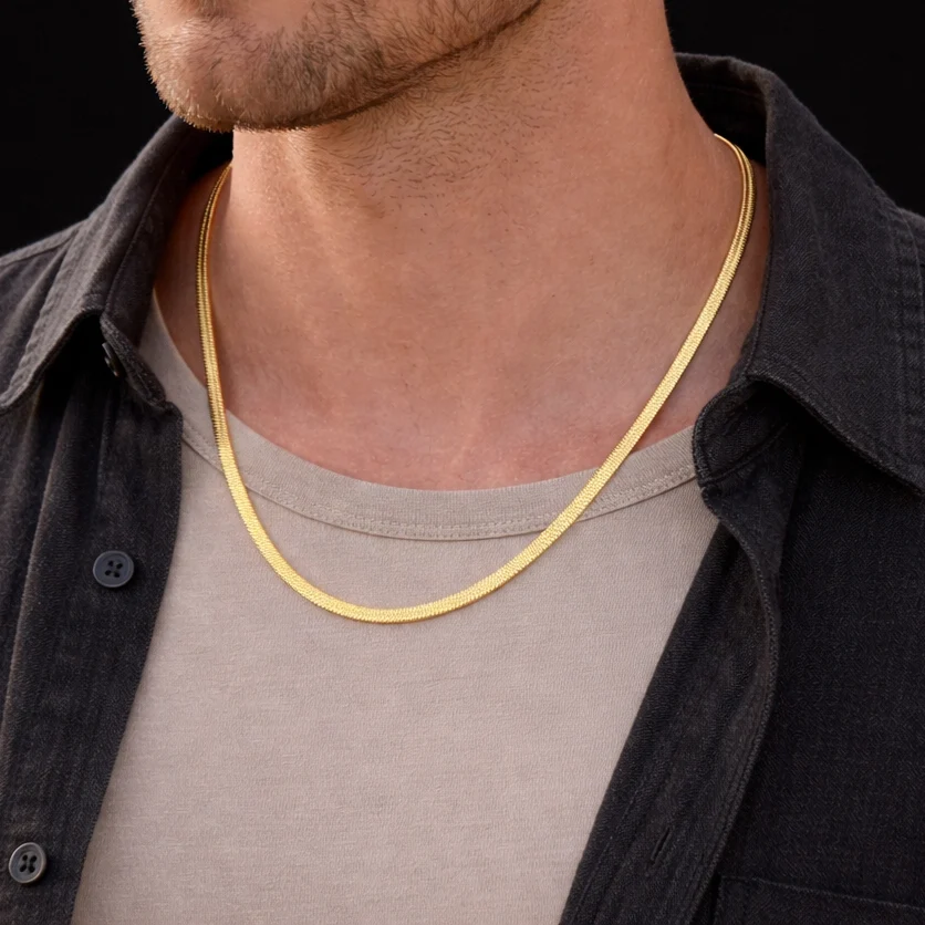 Gold flat snake chain necklace worn with layered neutral outfit