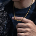 Gold snake chain necklace worn with black outfit