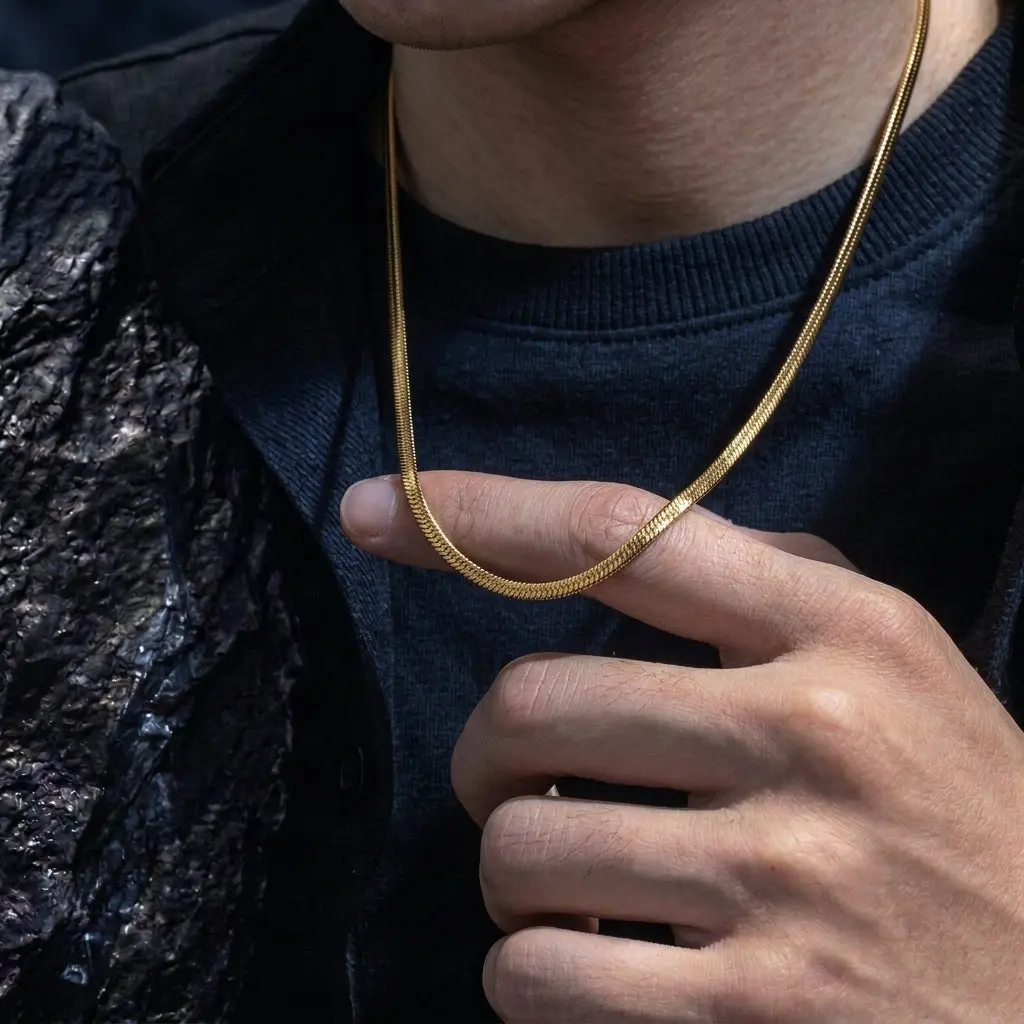 Gold snake chain necklace worn with black outfit