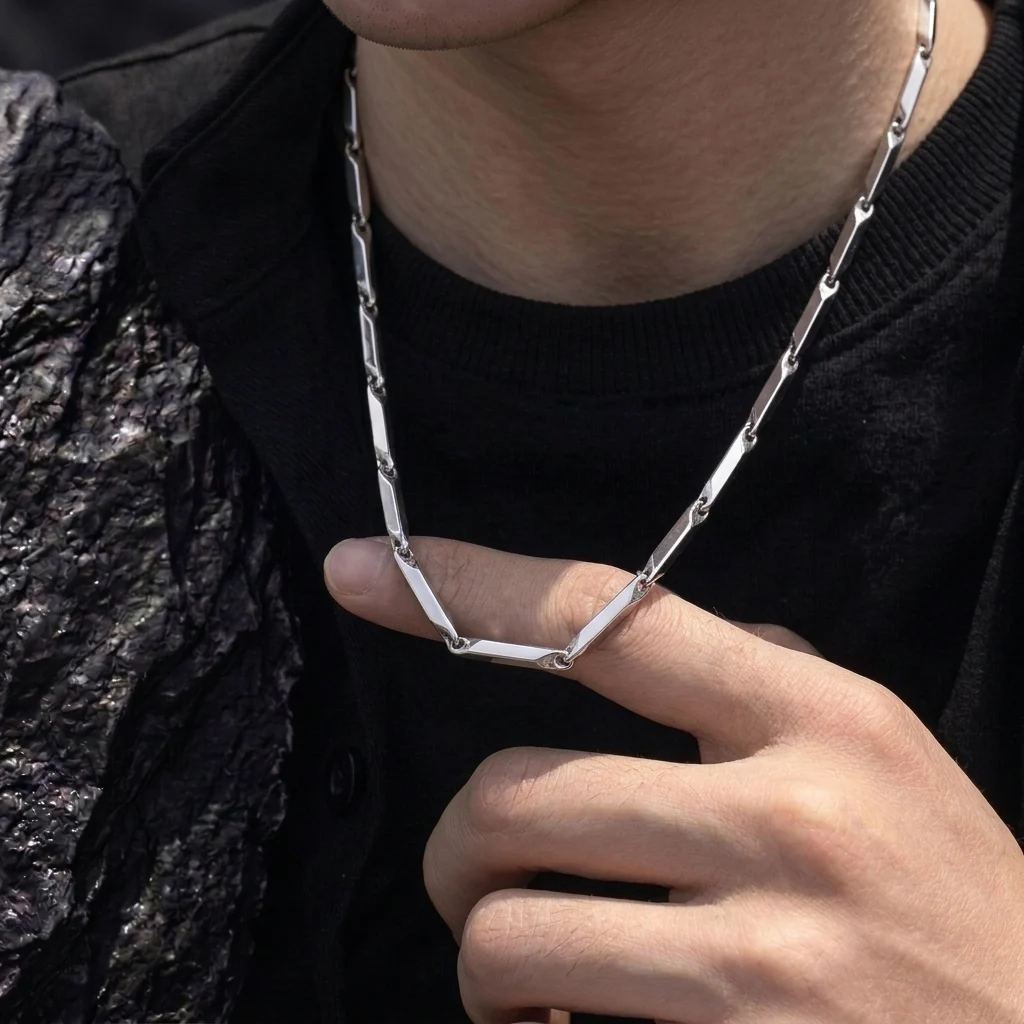 Silver geometric link chain necklace worn with black outfit
